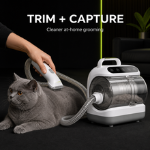 Cordless clipper trims cat fur while the grooming vacuum captures loose hair